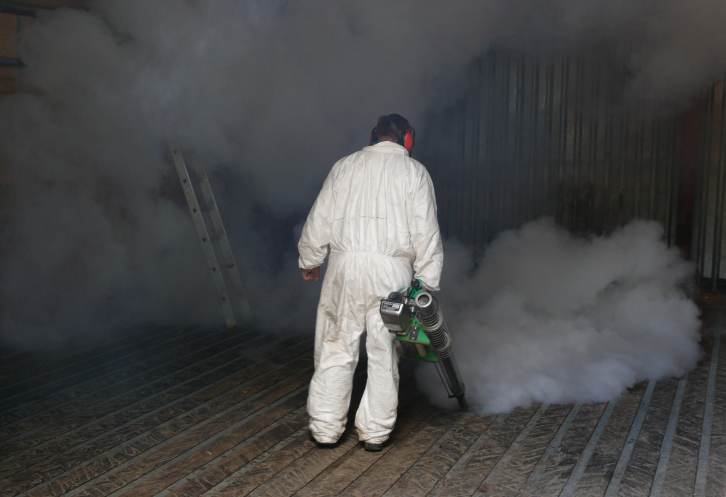 Person in hazmat suit fumigating a grainstore